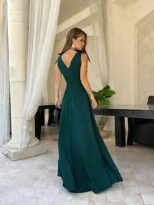 Detail of forest green evening dress featuring V-back and elegant shoulder bow straps