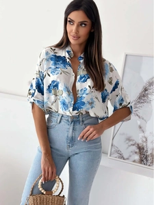 Detail shot of a white shirt with blue floral prints and rolled-up five-point sleeves