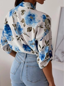 Detail of floral printed shirt with blue flower patterns and buttoned half sleeves