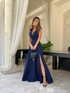 Detail of elegant navy blue evening dress featuring a high side slit and tied shoulder straps
