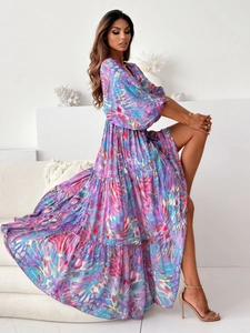 Detail of bohemian V-neck maxi dress with tie-dye print and side slit on layered skirt