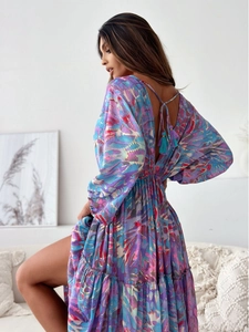 Detail view of bohemian V-neck dress featuring gold thread patterns and tassel back ties