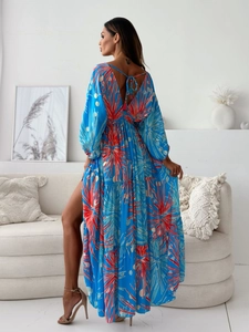 Detail of bohemian floral print dress with deep V-back and red tassels on blue fabric