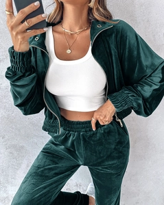 Detail view of dark green velvet tracksuit set showing zip jacket and elastic cuffs