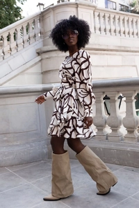 Detail of V-neck printed dress with geometric patterns and elegant ruffle hemline