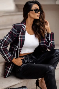 Detail of plaid blazer jacket with notched lapels and matching black leather trousers