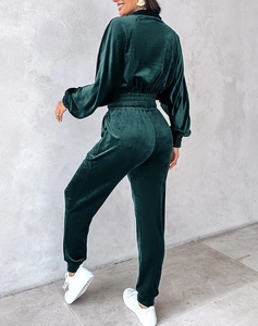Detail of forest green velvet tracksuit showing glossy fabric texture and elastic waist