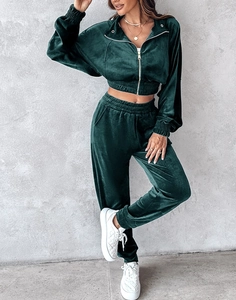 Detail of emerald green velvet tracksuit set showing zip jacket and jogger texture