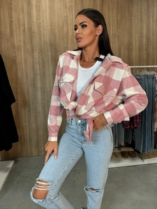 Detail of a pink and white plaid shacket featuring chest pockets and a button-down front