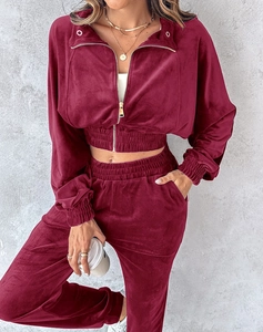 Macro detail of burgundy velvet tracksuit showing high-waist joggers and rich fabric luster