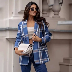 Chic women's blue plaid blazer jacket styled with jeans on a sunny urban street