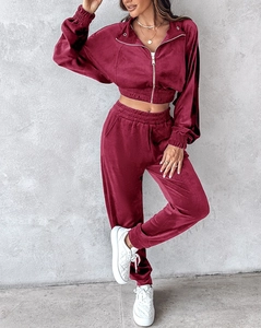 Detail view of the deep wine red velvet tracksuit showing fabric texture and ribbed cuffs