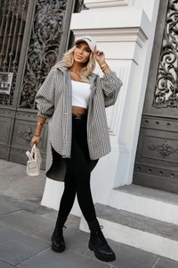 Dettaglio di una giacca camicia oversize da donna con motivo pied-de-poule bianco e nero