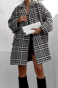 Détail du manteau classique pied-de-poule noir et blanc avec revers et boutons décoratifs