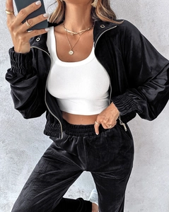 Close-up detail of premium black velvet tracksuit with metallic zipper and elastic cuffs