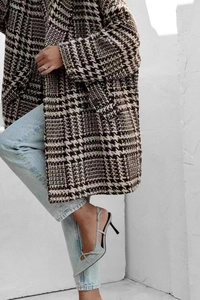 Vue de profil d'un long manteau oversize en laine pied-de-poule avec revers et boutons