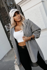 Dettaglio del motivo pied-de-poule su un cappotto scozzese da donna con taglio rilassato