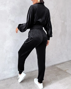Rear view of black velvet tracksuit featuring a cropped long-sleeve top and cinched trousers