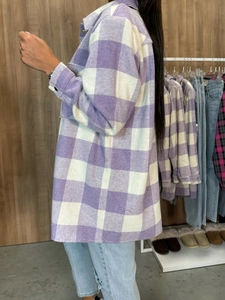 Detail of a purple plaid shacket showing thick brushed fabric texture and side slits