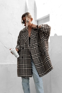 Photo street style d'un manteau ample en laine à motif pied-de-poule avec revers élégants