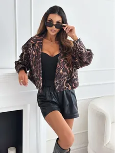 Detailed view of leopard print jacket fabric with black leather shorts and V-neck top
