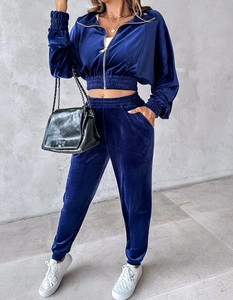 Detailed view of women's dark blue velvet tracksuit featuring ribbed cuffs and zip-up jacket