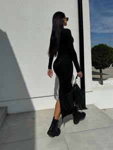 Détail de la maille extensible et de la fente latérale sur une robe longue noire