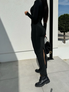Détail montrant la fente arrière et la coupe ajustée d'une robe noire à manches longues