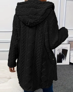 Détail de la veste noire à capuche en polaire avec motif tricoté en losange et coupe ample