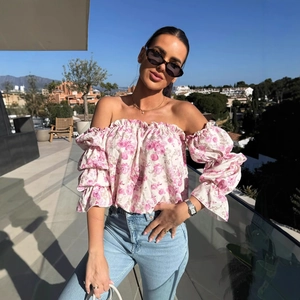 Camicetta floreale con spalle scoperte, maniche a balze e jeans azzurri coordinati