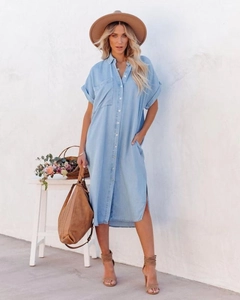 Detail of light blue denim shirt dress featuring classic collar and functional chest pocket