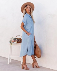Detail of light blue denim midi shirt dress featuring side slits and a classic collar