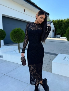 Détail de la dentelle florale noire sur une robe mi-longue moulante avec manches transparentes