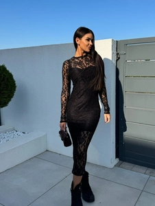 Détail de la texture dentelle florale complexe sur une robe noire moulante élégante