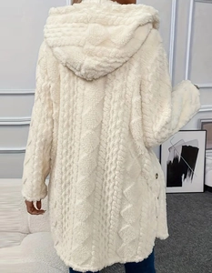 Détail d'une veste en polaire blanche avec des motifs tricotés en losanges complexes