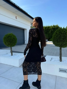 Détail d'une robe longue en dentelle noire ajustée montrant la texture ajourée et doublure