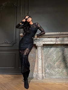 Gros plan sur les motifs floraux complexes en dentelle noire et le tissu texturé de la robe