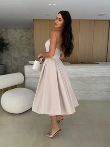 Detailed side view of light pink tube midi dress with voluminous satin skirt
