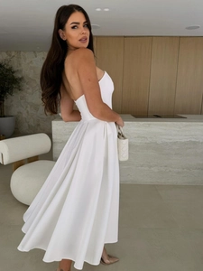 Detail of elegant white tube midi dress showing glossy satin fabric and pleated A-line skirt