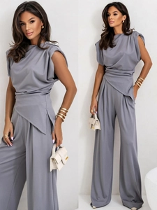 Detail of dark grey sleeveless pleated top and matching wide-leg trousers set