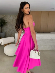 Detail of elegant fuchsia strapless dress showing flowy pleated skirt and open back design