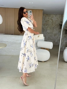 Close-up of cream floral dress with puff sleeves and wood interior background