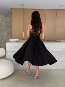 Back view of a black high-low hem bandeau dress with an elegant full umbrella skirt