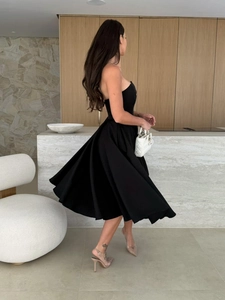 Detail of elegant black strapless midi dress with slim waist and A-line skirt