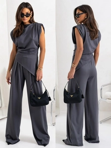 Detail of dark grey sleeveless jumpsuit with irregular wrap design and wide-leg trousers