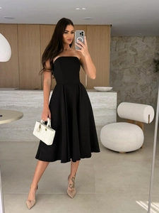 Detail of a black strapless A-line dress featuring pleated skirt and cinched waist design