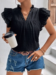 Detail of black V-neck top showing ruffled sleeves and textured fabric on a woman
