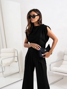 Detail of elegant black sleeveless top with asymmetrical hem and wide-leg trousers set