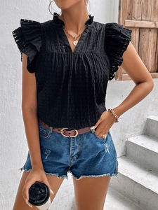 Detail of black V-neck top showing ruffled sleeves and textured waffle fabric texture