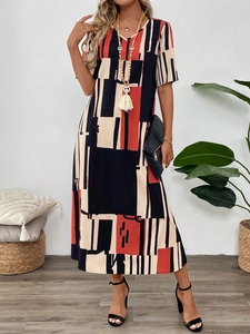 Detail of V-neck summer dress with red and black geometric print and tassel necklace